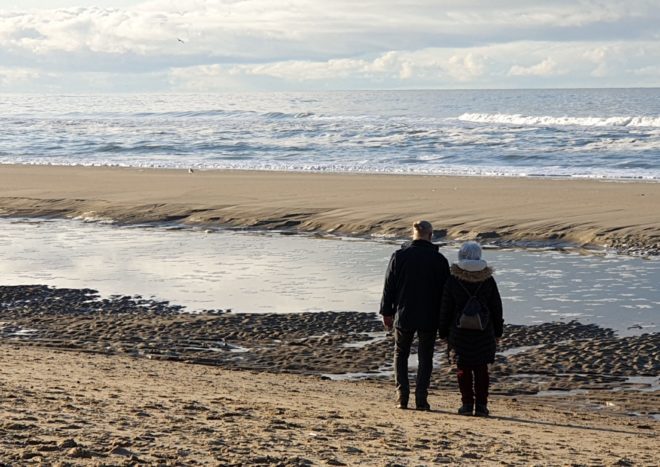 Foto van een stel dat een strandwandeling maakt bij De Koog op Texel